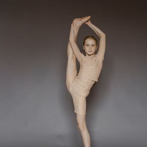 A person performing a deep stretching pose, showing flexibility.