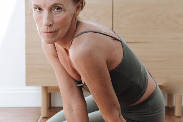 Person moving gracefully from one yoga posture to another in a bright studio.