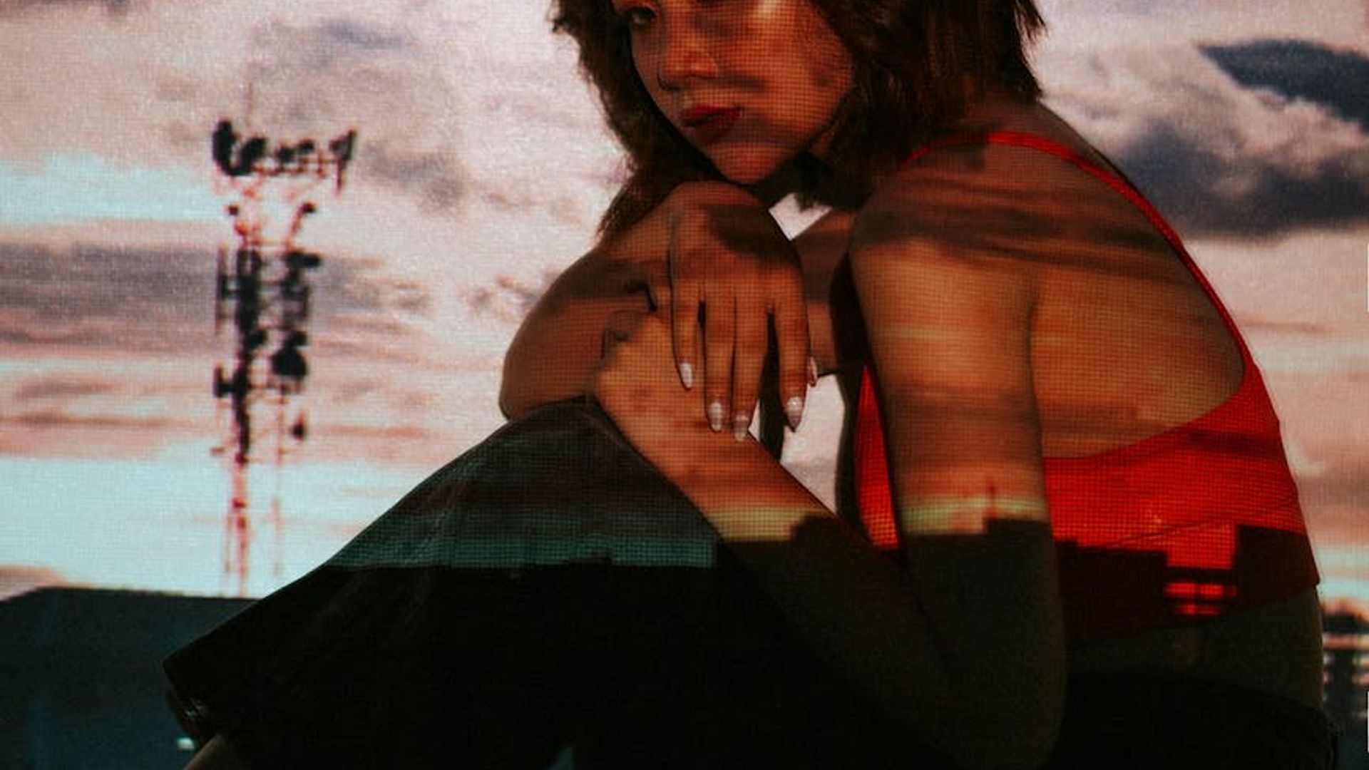 Silhouette of a person in a dynamic yoga pose against a dark, atmospheric background.